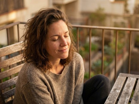 Professional sitting thoughtfully on an outside bench representing high-functioning anxiety and cognitive behavioral therapy for high-achieving individuals